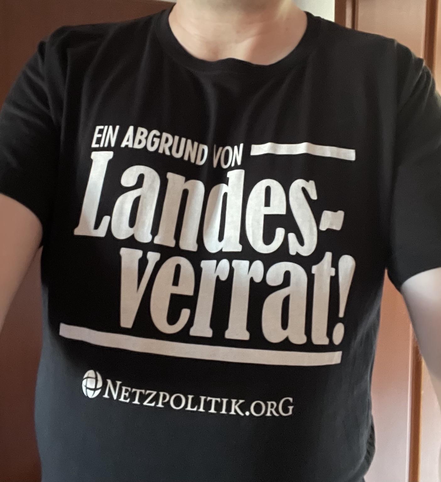 Schwarzes T-Shirt mit dem Schriftzug „Ein Abgrund von Landesverrat! - 🌍Netzpolitik.org“
